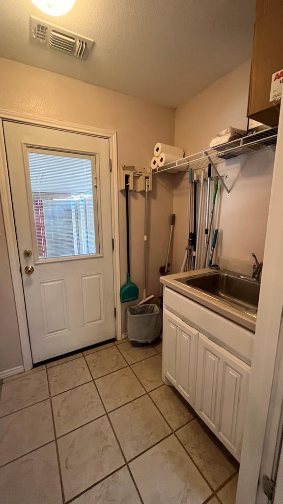 interior space featuring light tile patterned floors and sink