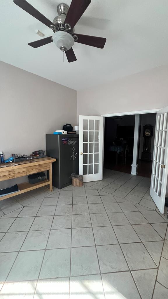 interior space featuring ceiling fan, french doors, and tile patterned floors