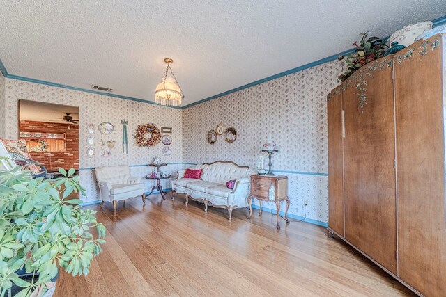 living room featuring a textured ceiling, a wood stove, and brick wall