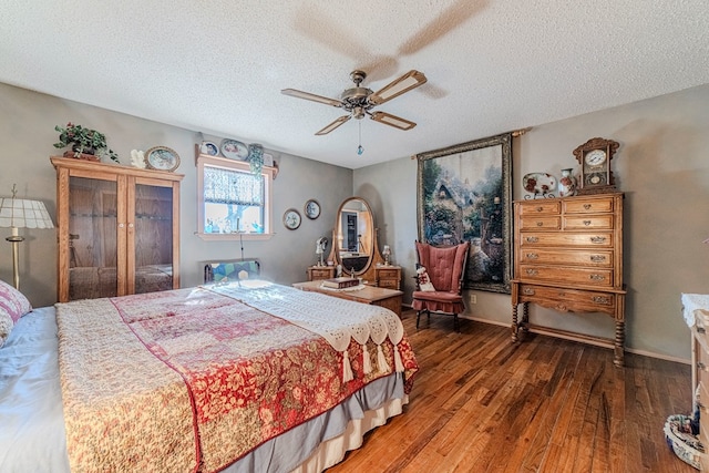 bedroom featuring dark hardwood / wood-style flooring, a textured ceiling, and ceiling fan