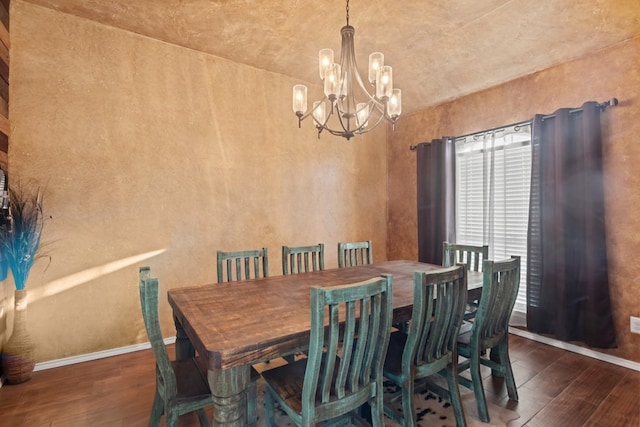 dining area with dark hardwood / wood-style flooring and a chandelier