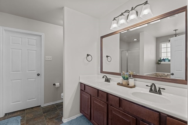 bathroom featuring a shower with door, vanity, and toilet