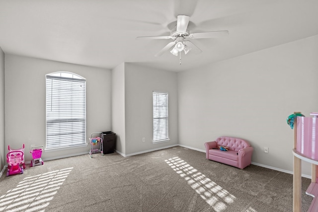 recreation room with light carpet and ceiling fan