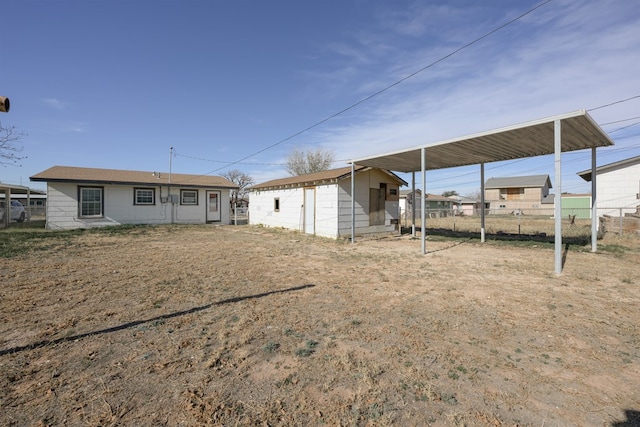 back of house with an outbuilding and a carport