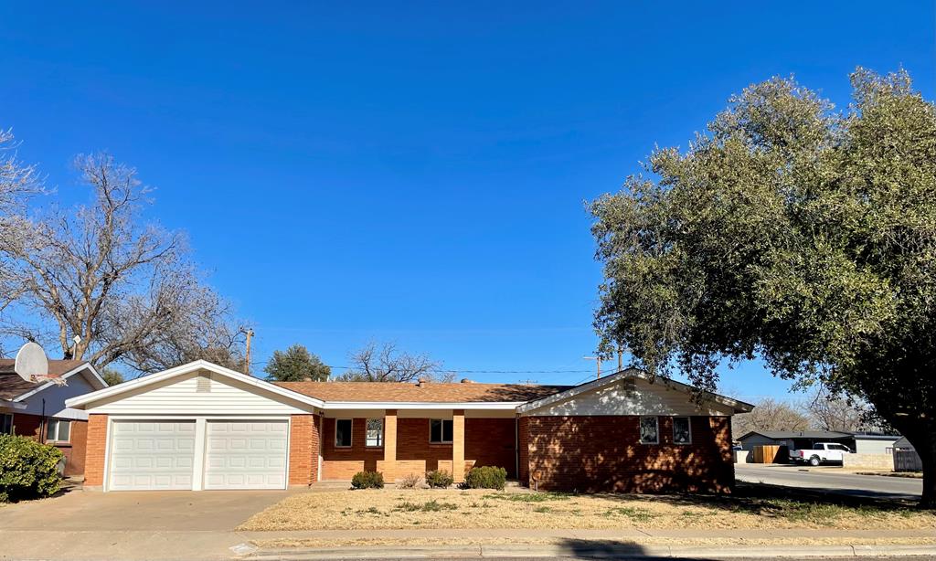 single story home with brick siding, driveway, and a garage