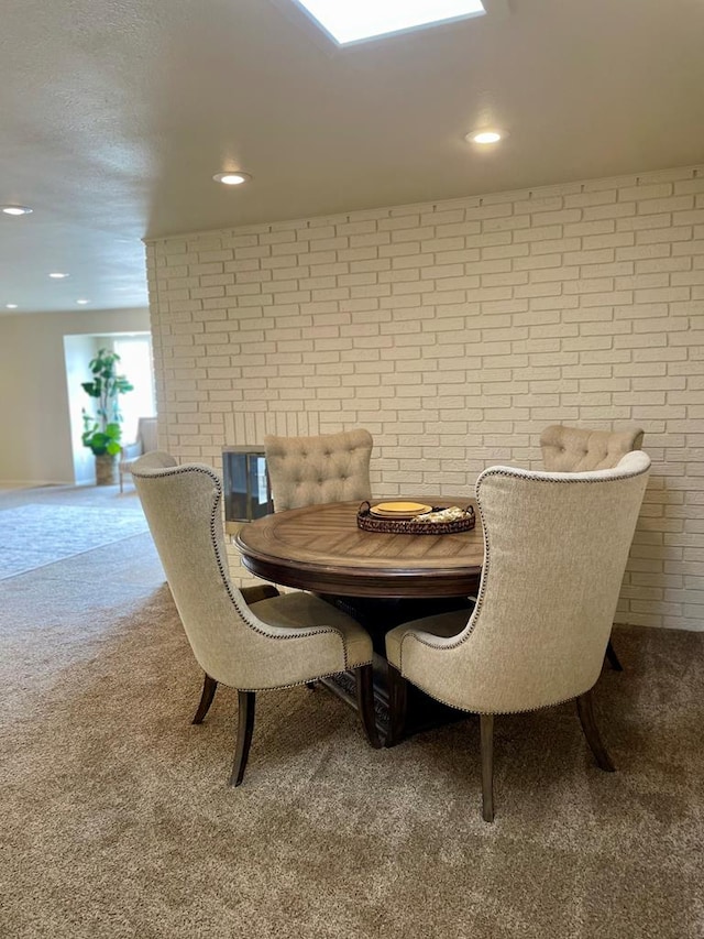 carpeted dining room featuring recessed lighting and brick wall