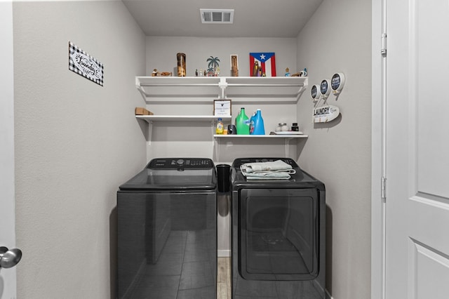 washroom featuring laundry area, washing machine and dryer, and visible vents