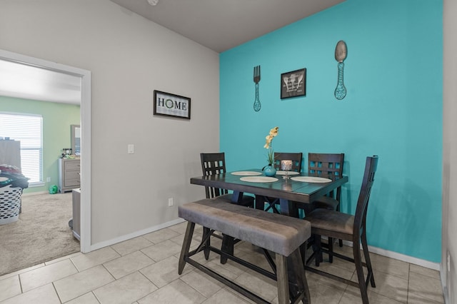 dining area with light colored carpet, baseboards, and light tile patterned floors