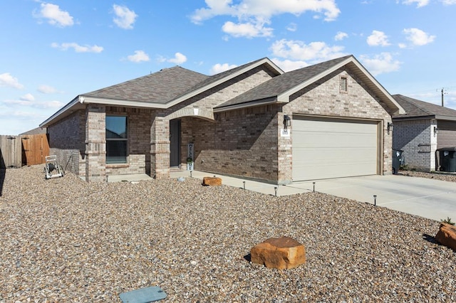 view of front of property featuring concrete driveway, roof with shingles, an attached garage, fence, and brick siding