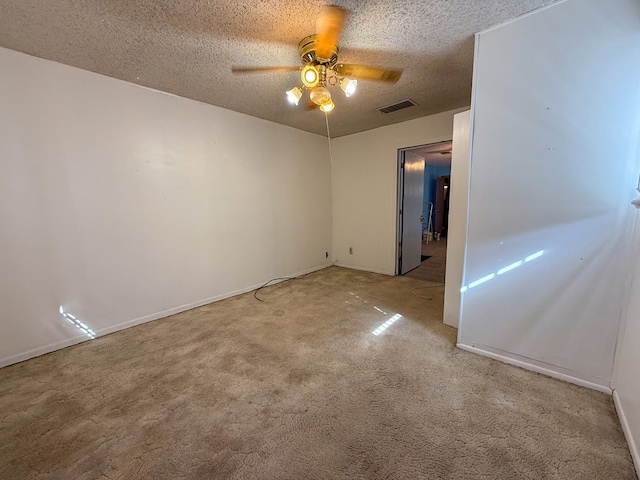 carpeted spare room with ceiling fan and a textured ceiling