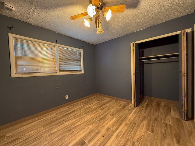 unfurnished bedroom with a textured ceiling, a closet, and ceiling fan