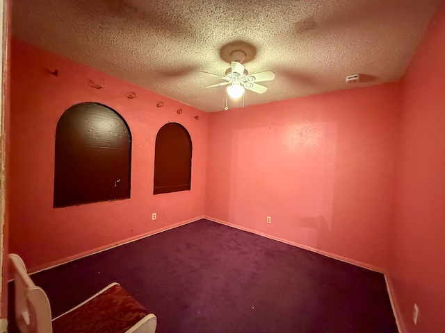 spare room with carpet, ceiling fan, and a textured ceiling