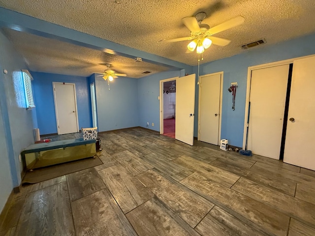 interior space with ceiling fan and a textured ceiling