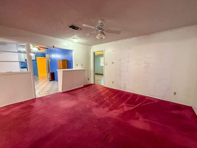 unfurnished room with carpet flooring, a textured ceiling, and ceiling fan