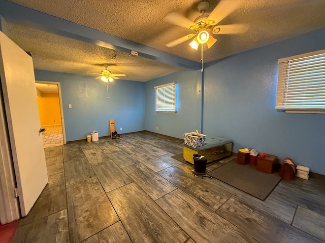 unfurnished bedroom featuring ceiling fan, beamed ceiling, and a textured ceiling