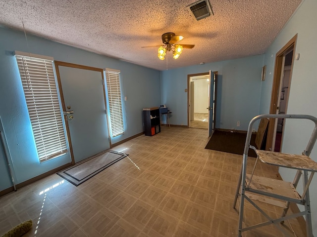 entryway with ceiling fan and a textured ceiling