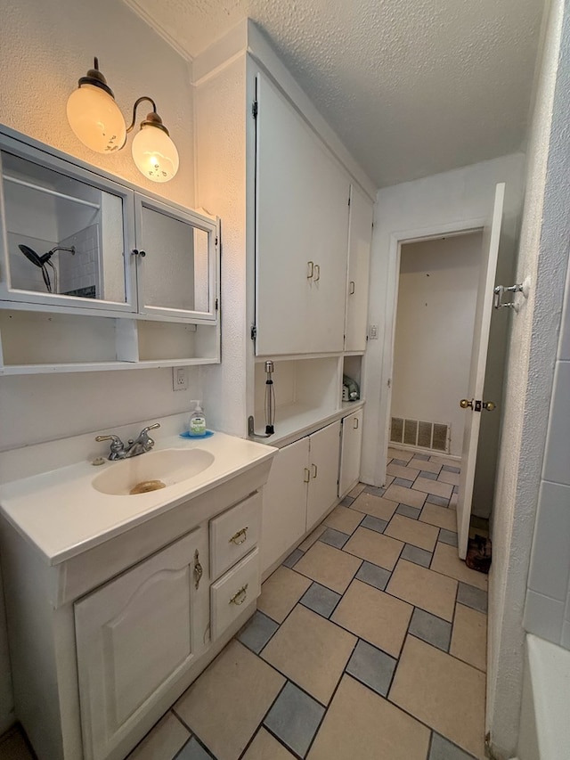 bathroom featuring vanity, a textured ceiling, and tile patterned flooring