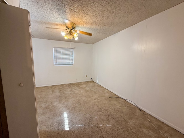 carpeted empty room featuring ceiling fan and a textured ceiling