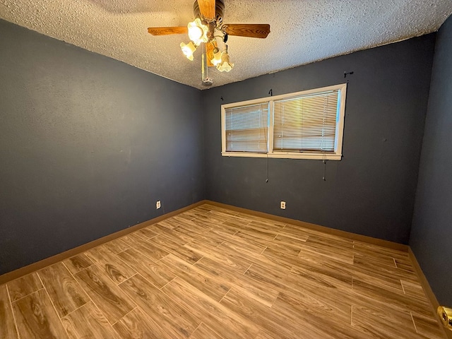 empty room with ceiling fan and a textured ceiling