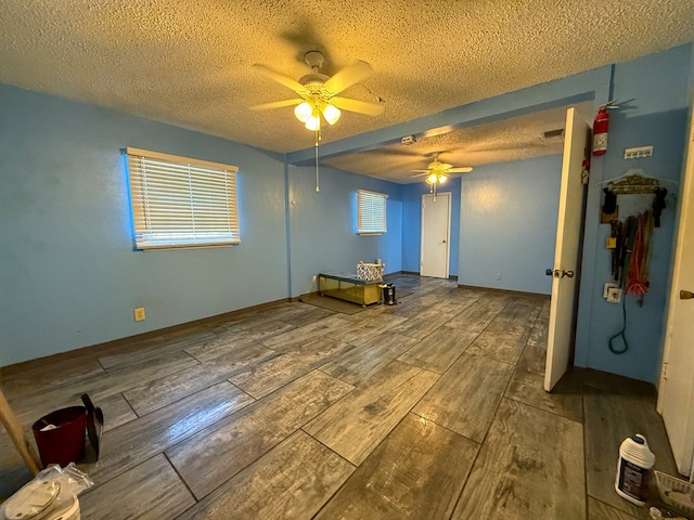 unfurnished room with ceiling fan and a textured ceiling