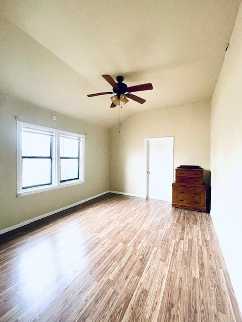 empty room featuring ceiling fan, lofted ceiling, and light hardwood / wood-style flooring