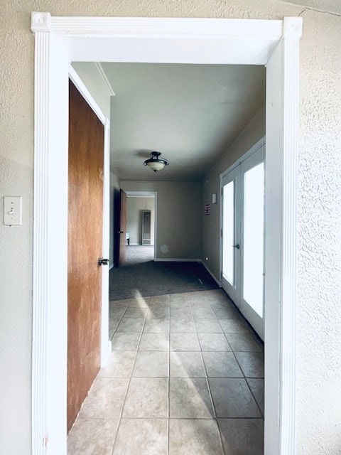 corridor with french doors and light tile patterned floors