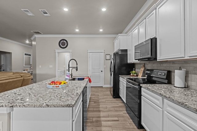 kitchen with visible vents, a sink, an island with sink, and black appliances