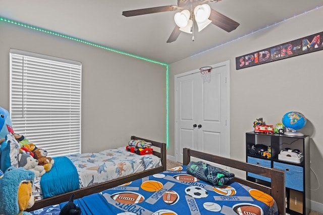 bedroom with a ceiling fan, a closet, and baseboards