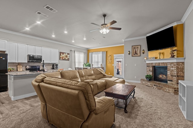 living area with ornamental molding, visible vents, a fireplace, and baseboards