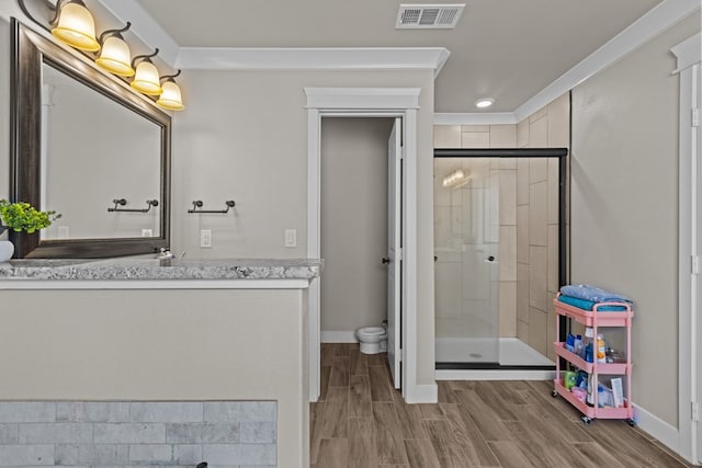 full bathroom featuring visible vents, wood tiled floor, a shower stall, vanity, and baseboards