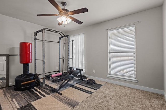 workout room featuring a ceiling fan, carpet, and baseboards