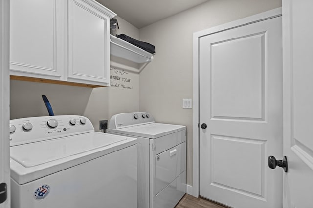 laundry room with cabinet space, washer and clothes dryer, and wood finished floors