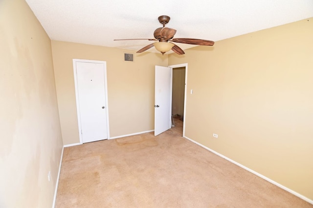 carpeted spare room featuring ceiling fan and a textured ceiling