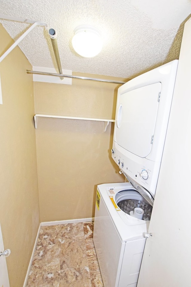 washroom featuring a textured ceiling and stacked washing maching and dryer