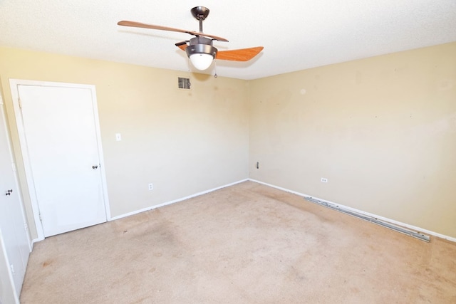 unfurnished room featuring ceiling fan, light carpet, and a textured ceiling