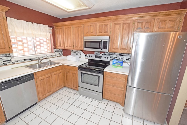 kitchen with tasteful backsplash, appliances with stainless steel finishes, light tile patterned flooring, and sink