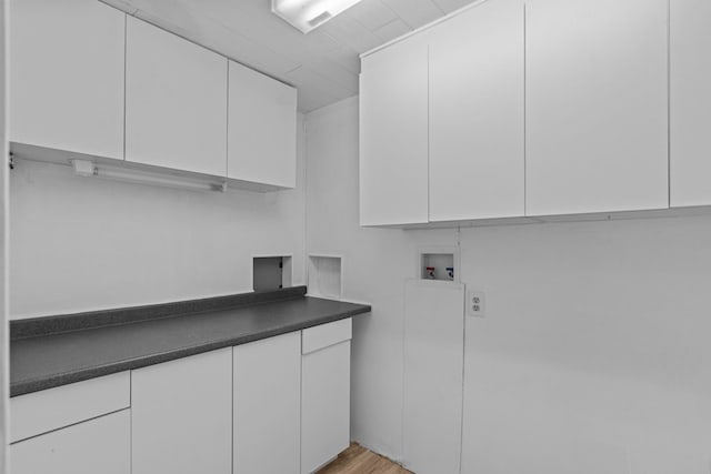 laundry room featuring hookup for a washing machine, cabinets, and light hardwood / wood-style floors