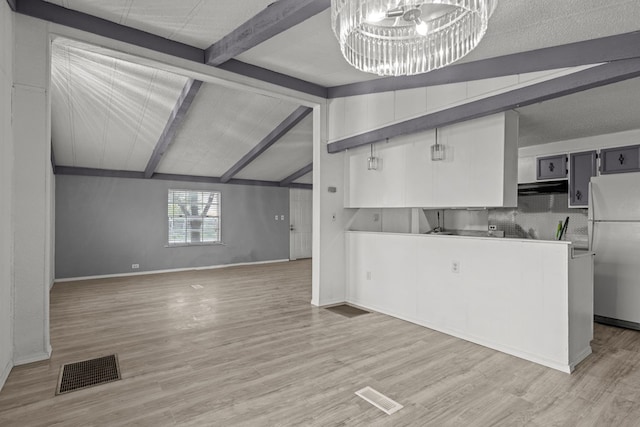 kitchen with vaulted ceiling with beams, wood-type flooring, a notable chandelier, and white refrigerator