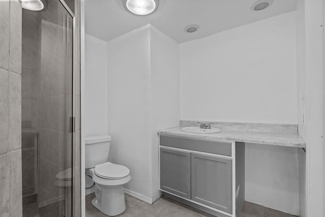 bathroom featuring tile patterned floors, vanity, toilet, and an enclosed shower