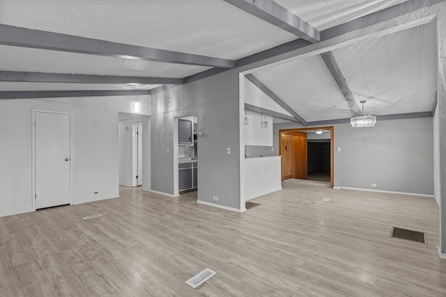 unfurnished living room featuring a textured ceiling, light wood-type flooring, lofted ceiling with beams, and a notable chandelier