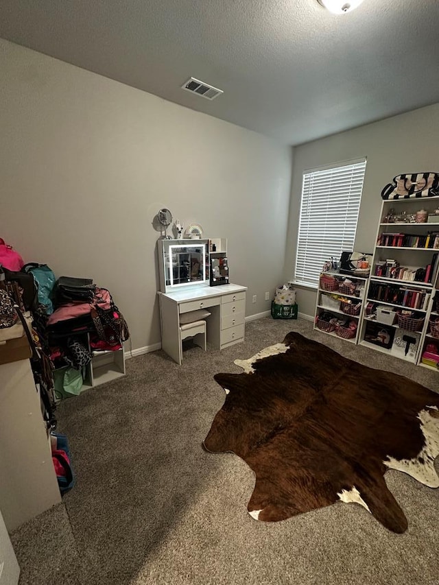 interior space with carpet, visible vents, a textured ceiling, and baseboards