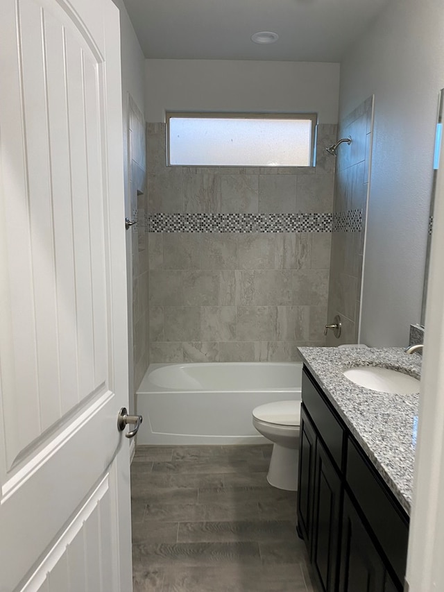 bathroom featuring vanity, shower / bathing tub combination, wood finished floors, and toilet