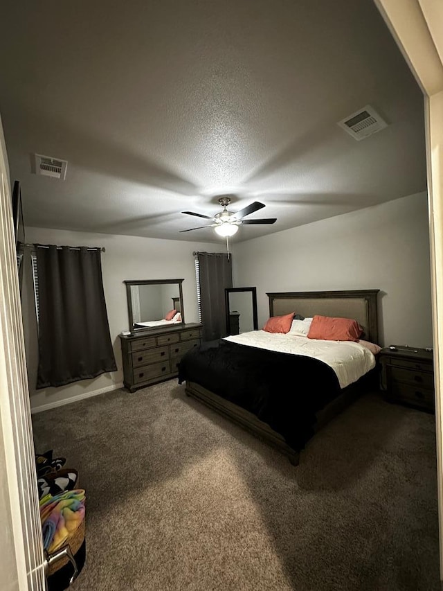 carpeted bedroom featuring a textured ceiling, visible vents, and a ceiling fan