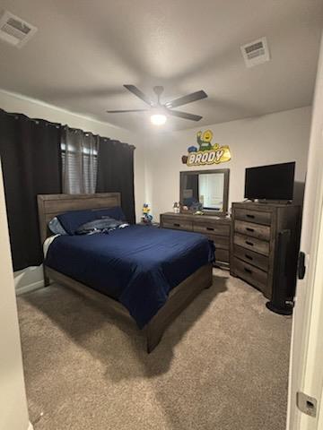 bedroom featuring light carpet, visible vents, and a ceiling fan