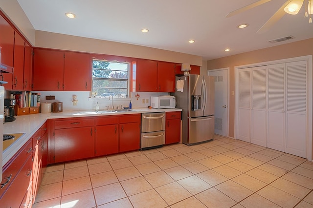 kitchen featuring ceiling fan, sink, light tile patterned flooring, and appliances with stainless steel finishes