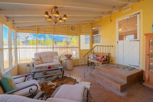 sunroom featuring plenty of natural light, beam ceiling, and ceiling fan with notable chandelier