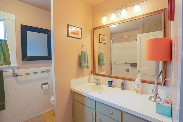 bathroom featuring toilet, vanity, tile walls, and a shower with shower curtain