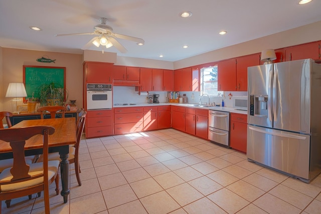 kitchen featuring light tile patterned floors, white appliances, ceiling fan, and sink