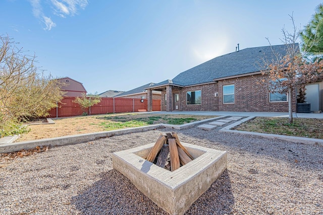 view of yard with a fire pit and central air condition unit