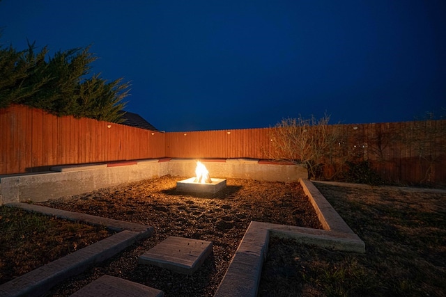 yard at night featuring a fire pit